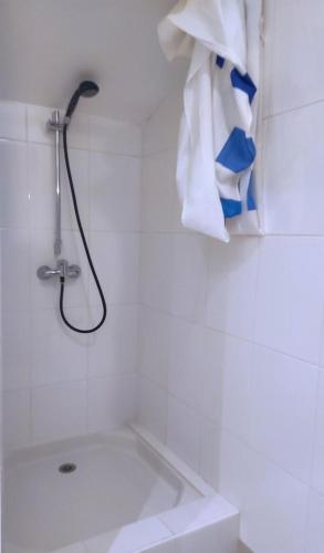 La salle de bains est pourvue d'une douche et d'un lavabo avec une serviette. dans l'établissement Le presbytere, à Douzy