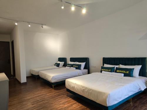 two beds in a room with lights on the wall at K Avenue Kota Kinabalu by Merveille - Sabah in Donggongon
