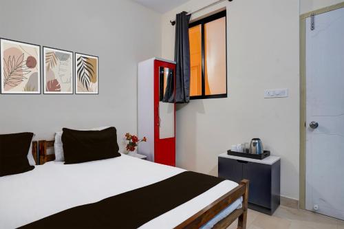 a bedroom with a white bed and a red door at Hotel O Hosur Road Near PES University in Bangalore