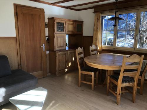 a living room with a wooden table and chairs at Apartment Sunnegruess by Interhome in Adelboden