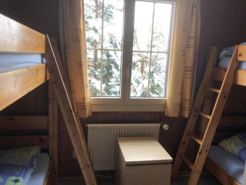 a room with two bunk beds and a window at Apartment Sunnegruess by Interhome in Adelboden