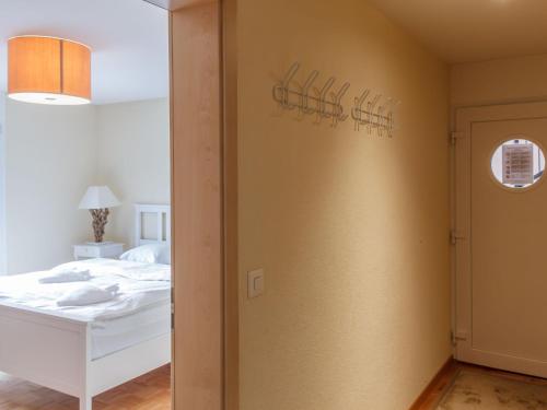 a bedroom with a bed and a wall with a window at Apartment Cook P1-2 by Interhome in Bouveret