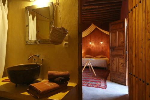 a bathroom with a sink and a mirror and a bed at La Ferme Berbere Adult only in El Harkat