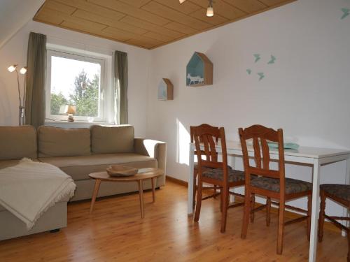 ein Wohnzimmer mit einer Couch und einem Tisch und Stühlen in der Unterkunft Lindenhof in Ahneby