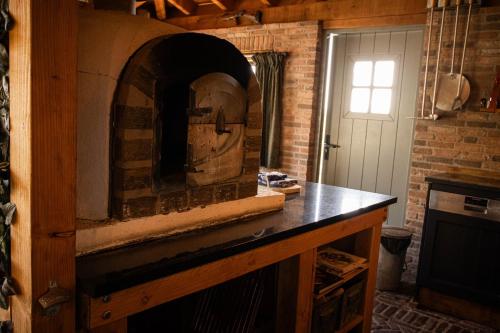 a stone oven in a kitchen with a brick wall at Landgoed Versteegh nabij heerlijkheid Mariënwaerdt in Beesd