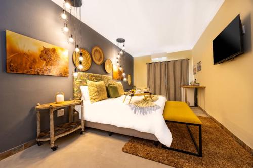 a bedroom with a bed and a tv on the wall at Zabini Lodge and Game Drives in Nelspruit