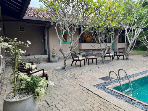 a patio with a pool and chairs and trees at Yala Villa in Yala