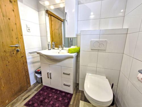 a white bathroom with a toilet and a sink at Apartment Wiesenhof by Interhome in Reith bei Seefeld