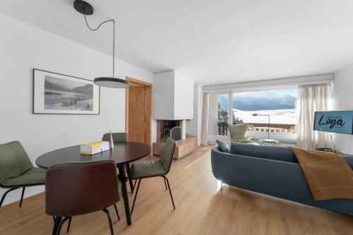 a living room with a blue couch and a table at Crest Alta 23 in Surlej