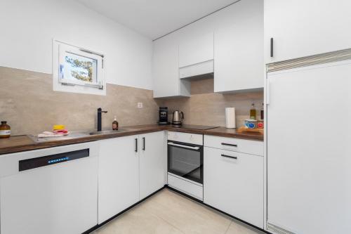 a white kitchen with white cabinets and appliances at Crest Alta 23 in Surlej