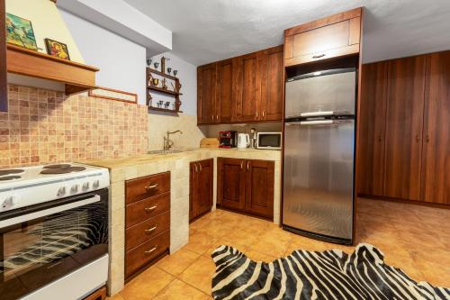 a kitchen with wooden cabinets and a stainless steel refrigerator at Manor House est. 1890 in Kastoria