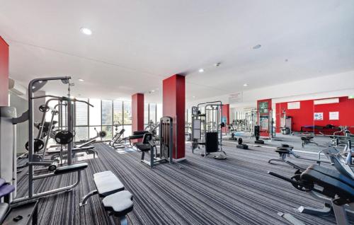 a gym with several treadmills and machines at Cozy Zetland 2 bedroom apt with pool, gym and parking in Sydney