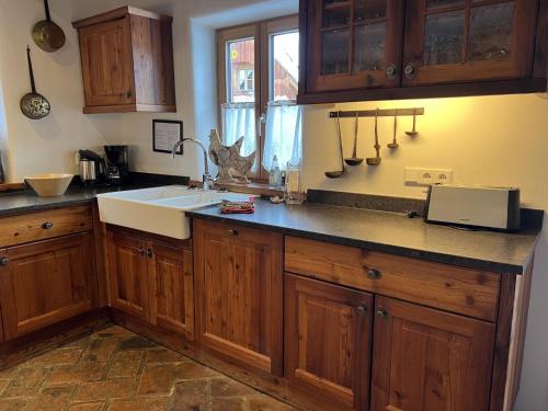 a kitchen with wooden cabinets and a sink at Holiday Home st martin chalets-1 by Interhome in Sankt Martin