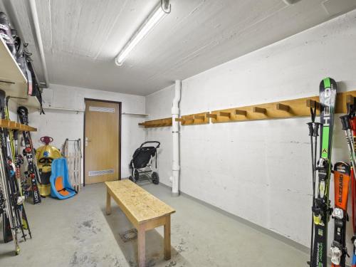 a room with skis on the wall and a bench at Apartment Triangel A Mohr by Interhome in Parpan