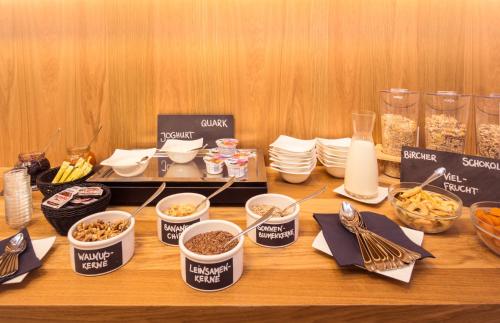 a table with bowls of food and utensils at Stadthotel Reich in Mellrichstadt