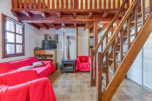 a living room with a red couch and a staircase at Magnimon 2 - Le Charme Rustique in Villard-Reculas
