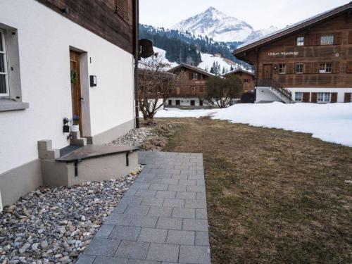 a bench on the side of a building with a snow covered mountain at Apartment Spitzhorn Nr- 1 by Interhome in Gsteig