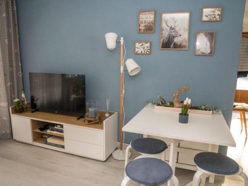 a living room with a table and two chairs and a tv at Apartment Spitzhorn Nr- 1 by Interhome in Gsteig