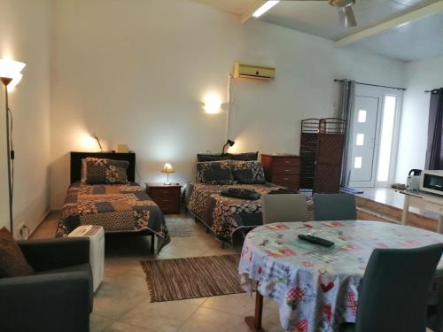 a living room with two beds and a table at Quinta do Medronhal Faro - casas de férias medronhal in Faro