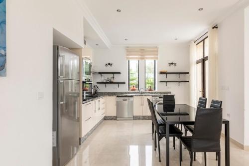 a kitchen with a table and chairs and a refrigerator at Villa Louda in Essaouira