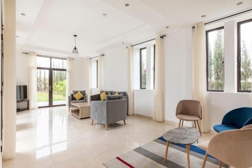 a living room with a couch and chairs and windows at Villa Louda in Essaouira