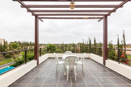 a patio with a table and chairs on a balcony at Villa Louda in Essaouira