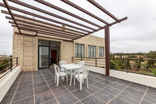 a patio with a table and chairs on a balcony at Villa Louda in Essaouira