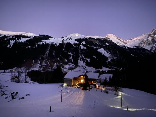 a house in the snow at night with lights at Apartment Chalet Bijou- 1 OG by Interhome in Lenk