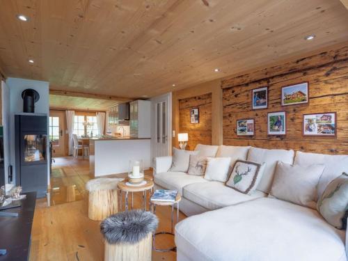 a living room with a white couch and wooden walls at Apartment Chalet Bijou- 1 OG by Interhome in Lenk