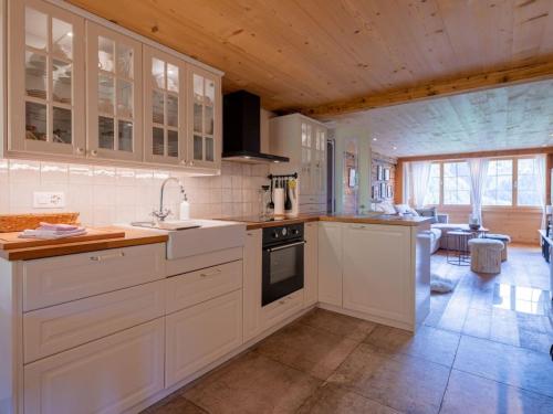 a kitchen with white cabinets and a counter top at Apartment Chalet Bijou- 1 OG by Interhome in Lenk