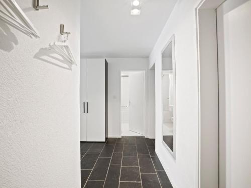 a hallway with white walls and a tiled floor at Apartment Nr-14 Haus Astoria by Interhome in Lenzerheide