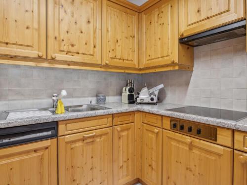 a kitchen with wooden cabinets and a sink at Apartment Casa Hermi by Interhome in Churwalden