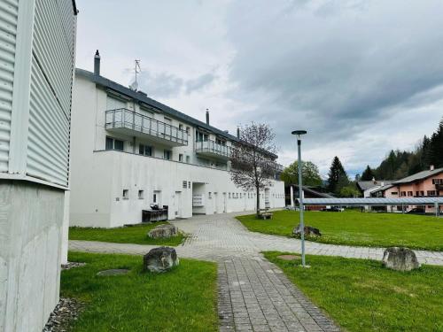 a white building with a walkway in front of it at Apartment Casa Hermi by Interhome in Churwalden