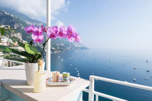 a table with a vase of flowers on a balcony overlooking the ocean at Palazzo Talamo in Positano