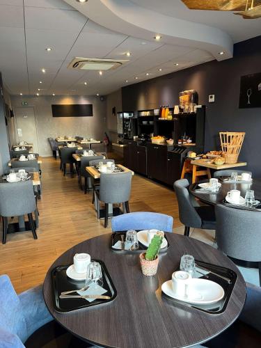 ベデにあるHotel le Broceliande - Sure Hotel Collection by Best Westernのテーブルと椅子のあるダイニングルームとレストラン