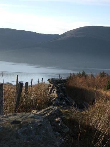 a fence on a hill next to a body of water at Knockderry Country House Hotel in Cove