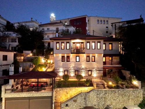 a large white building with lights on it at night at Manor House est. 1890 in Kastoria