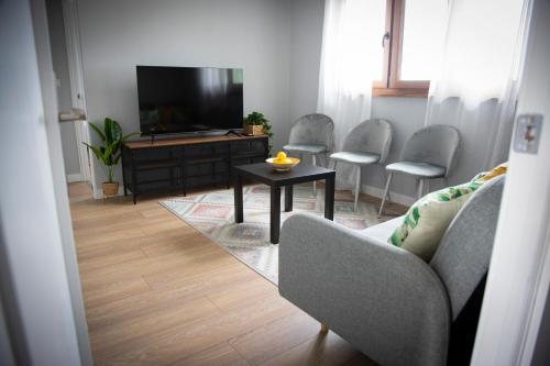 a living room with a tv and a table and chairs at Playa del Silencio 2 in Castañeras