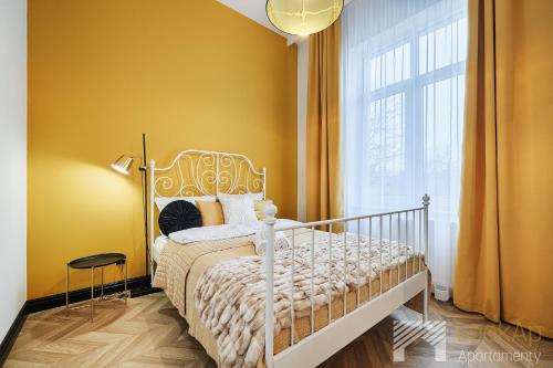 a bedroom with a white bed and a window at Kolorova Apart by LookAp - darmowy parking w centrum Łodzi! in Łódź
