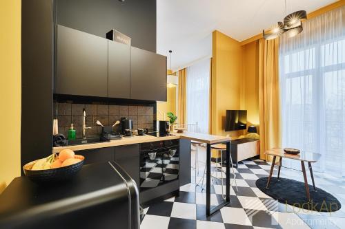 a kitchen with a black and white checkered floor at Kolorova Apart by LookAp - darmowy parking w centrum Łodzi! in Łódź