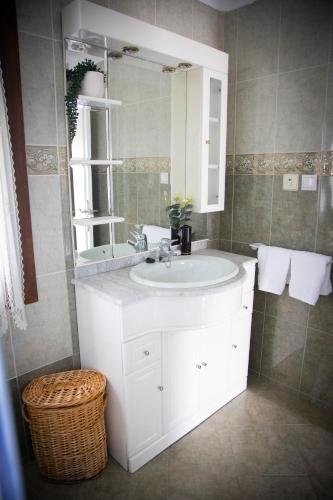a bathroom with a white sink and a mirror at Playa del Silencio 2 in Castañeras