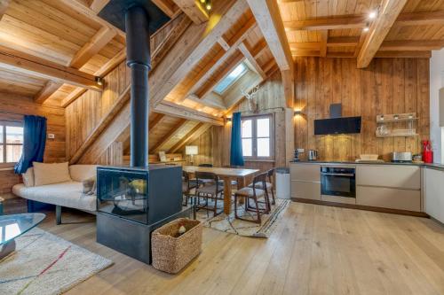 une cuisine et un salon avec une cheminée dans une cabane en rondins dans l'établissement Magnifique Appartement Le Taillefer, à Villard-Reculas