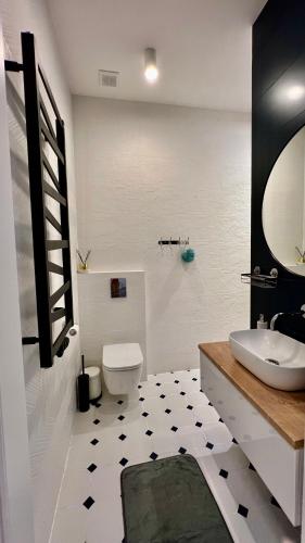 a white bathroom with a sink and a toilet at Long Island in Grudziądz