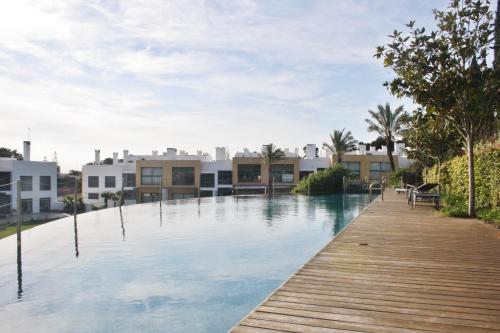 a swimming pool with a wooden walkway and houses at Charming Cascais Apt. in Cascais