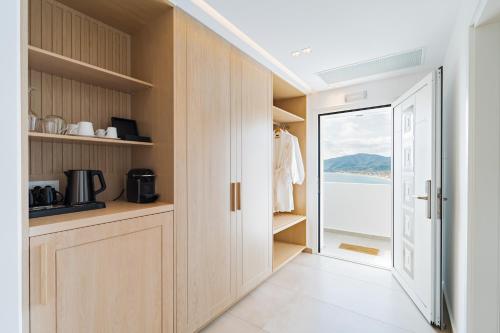 a kitchen with wooden cabinets and a door leading to a balcony at Cavo del Sol in Sarti