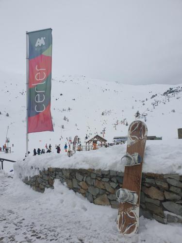 a snowboard leaning against a stone wall in the snow at Apartamento de la Marmota Cerler in Cerler