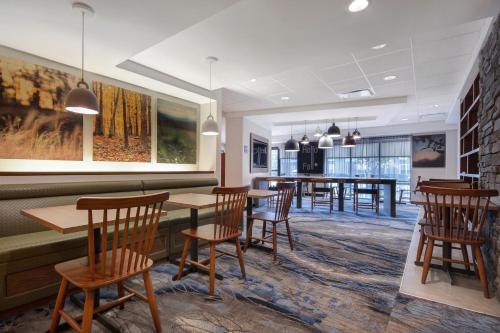 a restaurant with wooden tables and chairs and a dining room at Fairfield Inn and Suites by Marriott Rochester West/Greece in Rochester