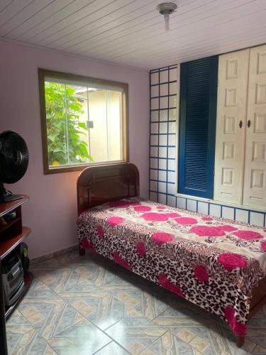 a bedroom with a bed and a window at Casa da Inês in Santa Teresa
