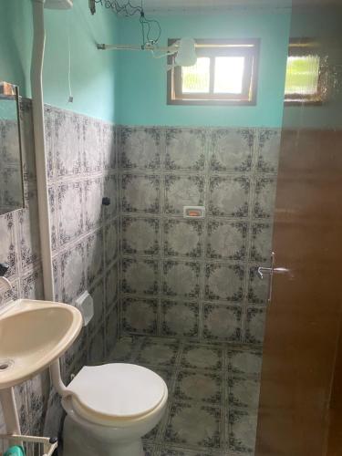 a bathroom with a toilet and a sink at Casa da Inês in Santa Teresa