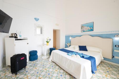 a bedroom with a bed and a suitcase in it at Palazzo Talamo in Positano